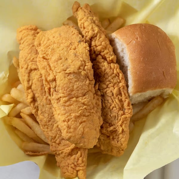 Louisiana Famous Fried Chicken meal with crispy fried chicken tenders, french fries, and a dinner roll.